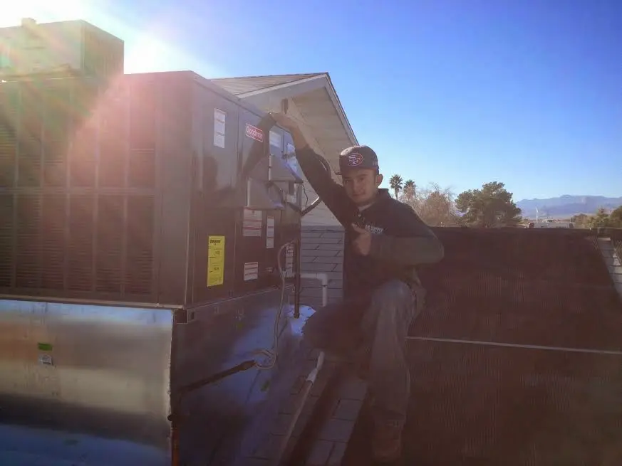 HVAC technician performing Heat Pump Repair on a rooftop unit in Kenosha